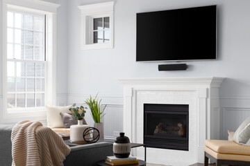 A fireplace detail with white subway tiles in a cozy living room and a television mounted above.