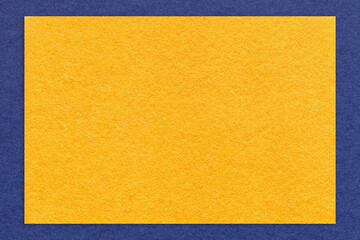 Texture of craft yellow color paper background with navy blue border, macro. Vintage kraft golden...