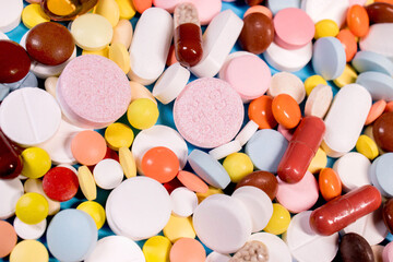 Background with the many colorful different capsules and pills. The concept of medical treatment