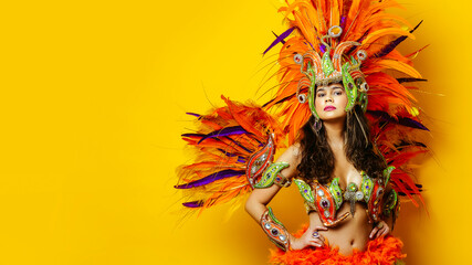 Beautiful brazilian woman in brazilian carnival costume on yellow background