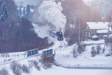 Retro steam train moves at winter day.