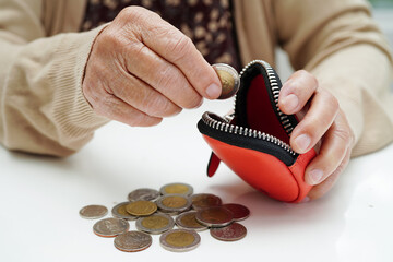 Retired elderly woman counting coins money and worry about monthly expenses and treatment fee...