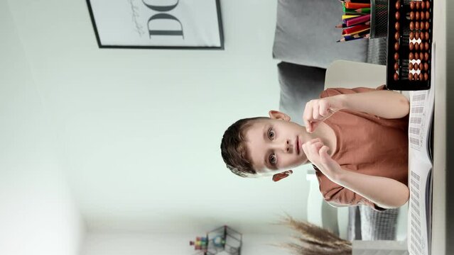 Little boy counting with the help of mental arithmetic and rejoices at the correct result. Mathematics in pleasure.