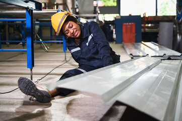 African American engineer woman injured leg kneel pain in metal sheet factory