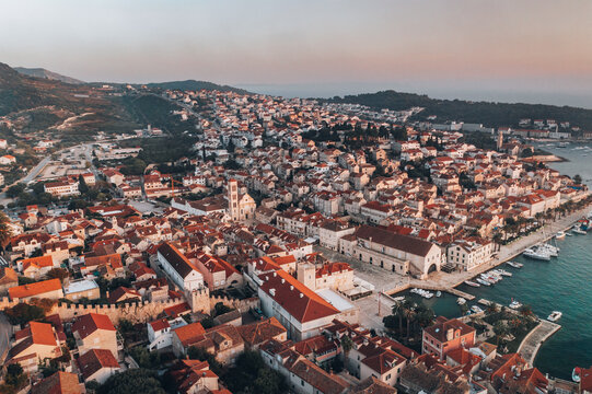 This breathtaking aerial photograph captures the stunning beauty of Hvar town at sunset from a birds eye perspective. The image showcases the town's charming architecture and winding streets.