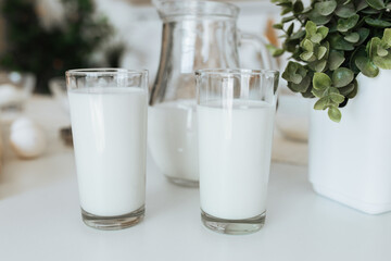 milk in a glass on a white table