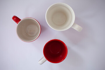 Three empty coffee or tea cups top view, red white mugs