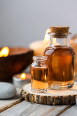 Concept of spa treatment in salon with pure organic natural oil. Atmosphere of relax, detention. Aromatherapy, candles, towel, wooden background. Skin care, body gentle treatment