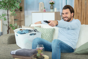 lazy man with remote control watching tv