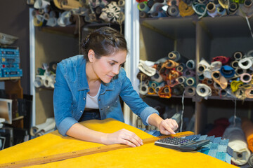 female fabric designer using calculator