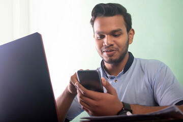 Man Chatting on a mobile phone  while ATTENDING ONLINE CLASS