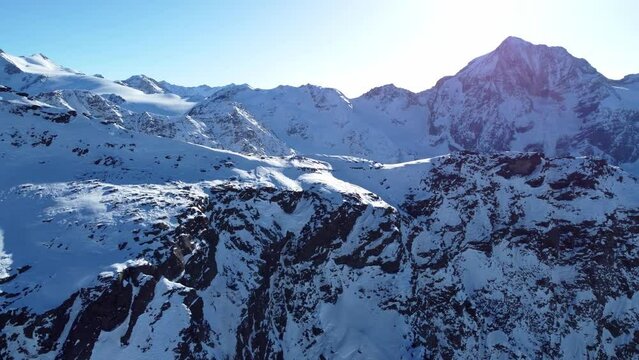 Aerial drone video of flight over scenic snowy mountain range and rocky ridge in winter in the European Alps