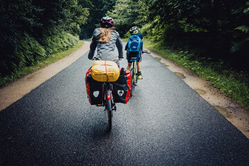 Bikepacking Abenteuer - Kleiner Junge und Mädchen auf einer Fahrradtour bei Regenwetter durch...