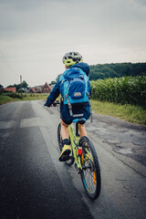 Fototapeta na wymiar Bikepacking Abenteuer - Kleiner Junge auf einer Fahrradtour bei Regenwetter durch Niedersachsen, Deutschland