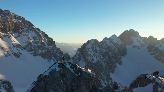 Mountaineer standing on Tajakopf mountain at sunset, Tirol, Austria