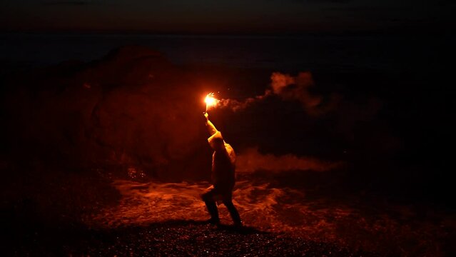 a lone person traveler in yellow wind protection gives a Help signal at night use Falsch feuer