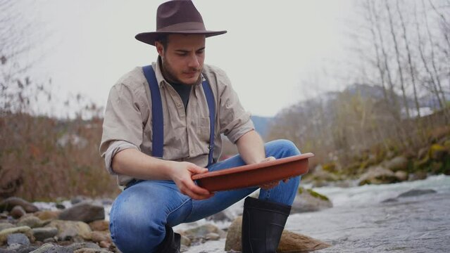 disappointed portrait of a male gold digger with wash gold Panning mining