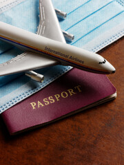 Travelling during corona virus epidemic. Passport with protective of facial mask and airplane