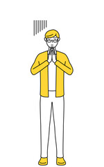 体の前で手を合わせて謝るカジュアルな格好をした若い男性