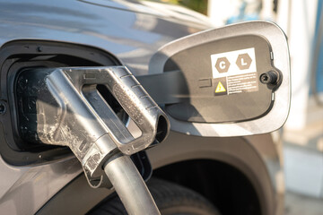 An EV car is plugging with the DC CSS type 2 charger head for refueling the energy. New technology...
