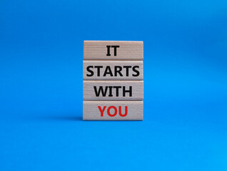 It starts with you symbol. Wooden blocks with words It starts with you. Beautiful blue background. Business and It starts with you concept. Copy space.