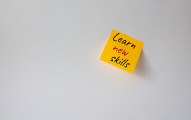 Learn new skills symbol. Concept words Learn new skills on orange steaky note. Beautiful white background. Business and Learn new skills concept. Copy space.