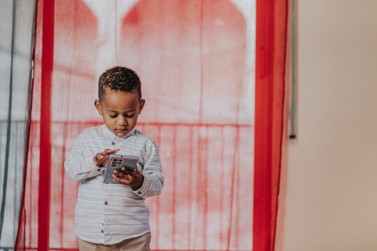 Cute focused boy using smartphone