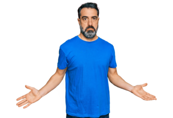 Middle aged man with beard wearing casual blue t shirt clueless and confused expression with arms and hands raised. doubt concept.