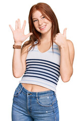 Young read head woman wearing casual clothes showing and pointing up with fingers number six while...