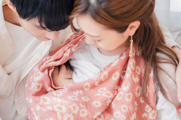 赤ちゃんに授乳をする母親とお父さん