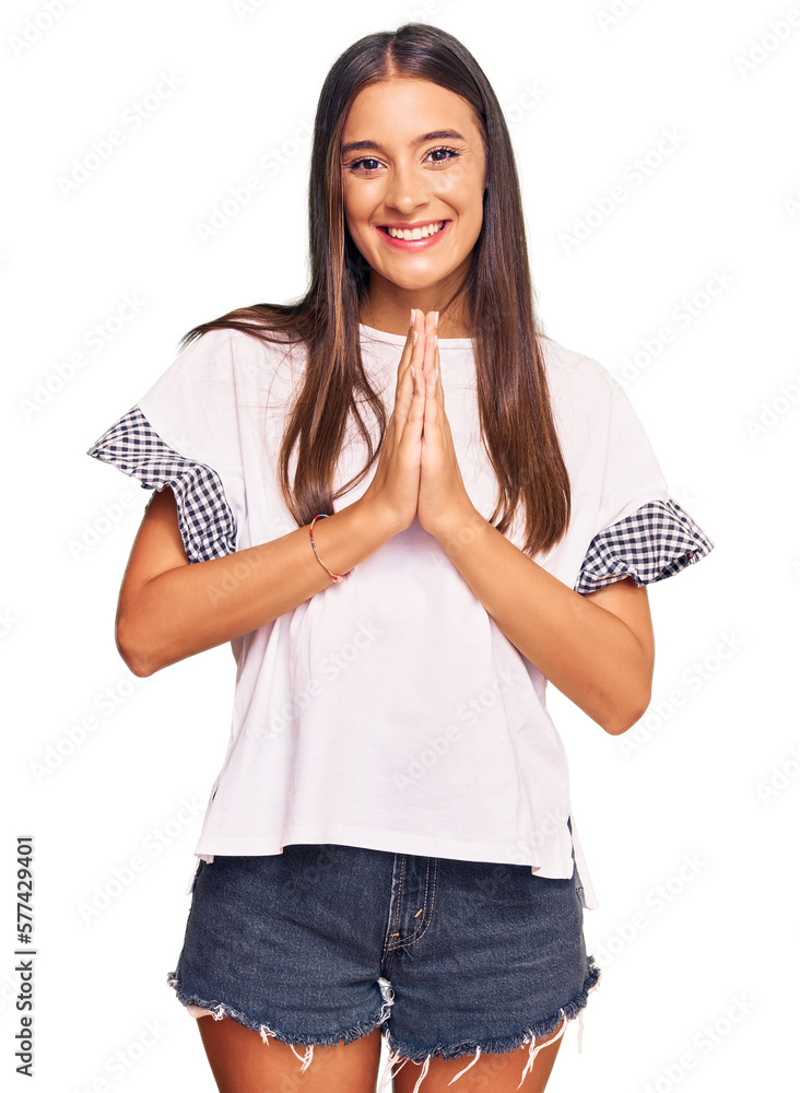 Wall mural Young hispanic woman wearing casual clothes praying with hands together asking for forgiveness smiling confident. - Wall murals