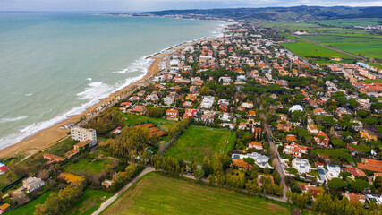 Aerial view of Santa Severa, a fraction of Santa Marinella, in the Metropolitan City of Rome, Italy. It is a small seaside town built along the coast. There are many small villas.