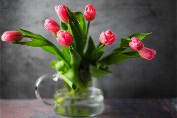 A bouquet of tulips in glass jar. Defocused, blurred background
