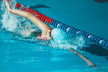 The theme of sports and endurance. Side view of a professional female swimmer with goggles at the...
