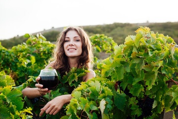 a woman in a dress with a glass of wine in a vineyard of nature