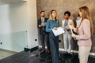 Businesswoman with candidate next to people waiting for job interview in a modern office