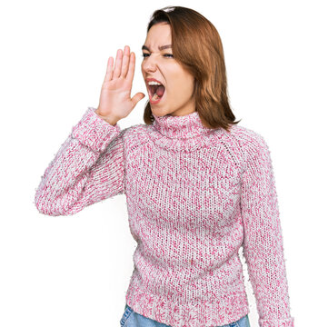 Young caucasian girl wearing wool winter sweater shouting and screaming loud to side with hand on mouth. communication concept.