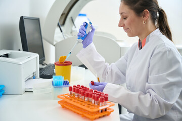 Laboratory employee holds test tube with blood samples
