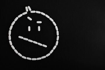 Emoji de cara de pastillas blancas desconfiado, sobre fondo negro.