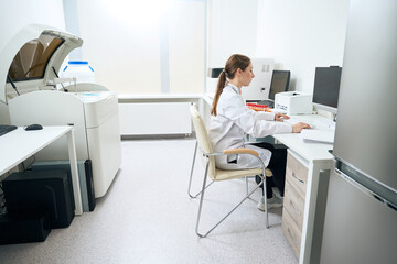Woman scientist at workplace in diagnostic laboratory in testing unit