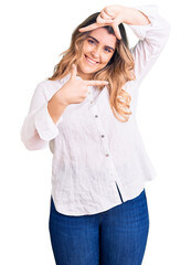 Fototapeta premium Young caucasian woman wearing casual clothes smiling making frame with hands and fingers with happy face. creativity and photography concept.