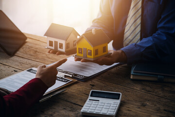 Real estate broker agent presenting and consult to customer to decision making sign insurance form agreement, buy and sell home model, concerning mortgage loan offer for and house insurance