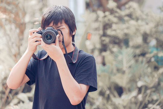 Young asian male photographer taking picture