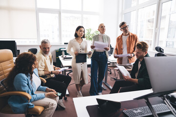 Coworkers looking through business documents in office
