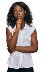 Fototapeta na wymiar Beautiful african young woman wearing casual clothes with hand on chin thinking about question, pensive expression. smiling with thoughtful face. doubt concept.