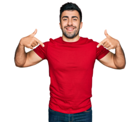 Hispanic man with beard wearing casual red t shirt looking confident with smile on face, pointing oneself with fingers proud and happy.