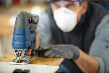 carpenters cutting wooden plank with a saw