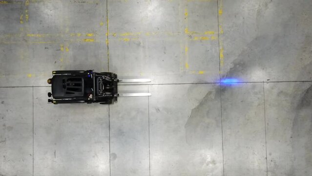 4K Aerial forklift enters the frame. Bird&rsquo;s eye warehouse top down powered industrial truck stock video.