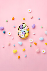 Easter Eggs with Sweets and Spring Flowers on Pink Background