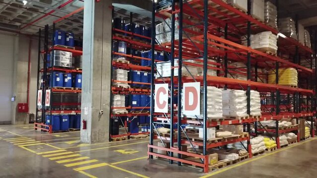 4K Aerial view of warehouse. Wide angle shooting of warehouse and shelves. Symmetrical view of palleted goods. Forest of shelves. Stock video.